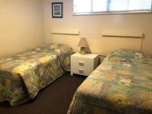 a bedroom with two beds and a lamp on a night stand at Sea Eagles Unit 4 in Caloundra