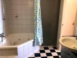 a bathroom with a bath tub and a sink at Sea Eagles Unit 4 in Caloundra