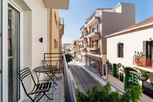 a balcony with a table and chairs on a street at Maistrali city suites in Agios Nikolaos