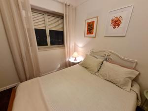 a bedroom with a white bed and a window at SolMar View Apartment, Azores in Ponta Delgada