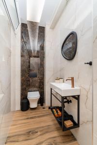 a bathroom with a sink and a toilet at Maistrali city suites in Agios Nikolaos +79 photos