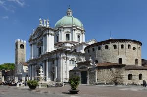 a large white building with a green dome and turrets at Piazza Duomo Cathedral View in Brescia