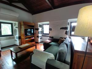 a living room with a couch and a tv at Casa dos Santos Historic Azorean Estate in Horta
