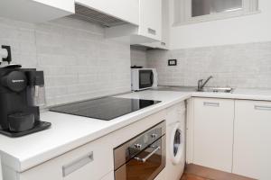 a white kitchen with a sink and a dishwasher at Piazza Duomo Cathedral View in Brescia
