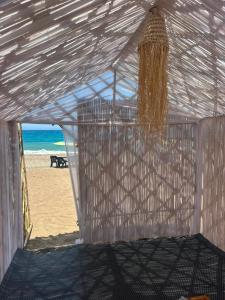 a white tent on a beach with the ocean at Chalets MB in Tarîfa +7 photos