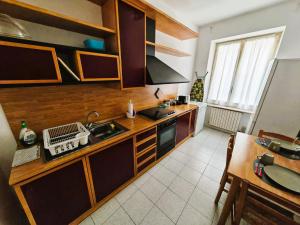 a kitchen with wooden cabinets and a sink and a table at GaribaldiCentrePort in Ancona +9 photos