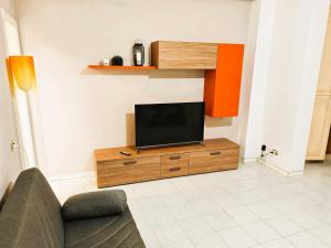 a living room with a flat screen tv on a cabinet at GaribaldiCentrePort in Ancona