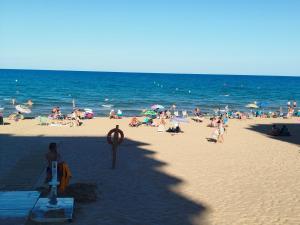 a crowd of people on a beach with the ocean at Le paradis de Lynn in Formentera de Segura