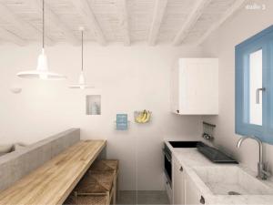 a kitchen with white cabinets and a counter top at Serifos Blue in Rámos