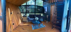 a living room with a blue couch and a staircase at Amanece en la naturaleza in Mazamitla