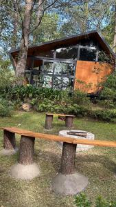 a wooden bench sitting in front of a building at Amanece en la naturaleza in Mazamitla