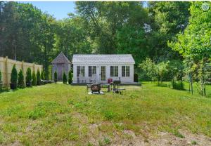 a small white shed in a yard with a picnic table at Lakefront Guesthouse w Sunrise View Dock in Stonington