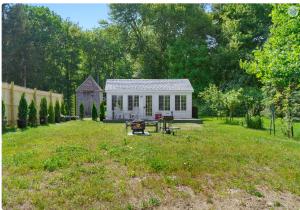 a small white house in the middle of a yard at Lakefront Guesthouse w Sunrise View Dock in Stonington +2 photos