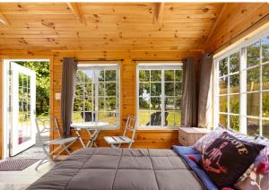 a bedroom with a bed in a room with windows at Lakefront Guesthouse w Sunrise View Dock in Stonington