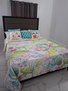 a bed with a colorful comforter and pillows on it at Nyack's Palace And Boutique in Beaulieu