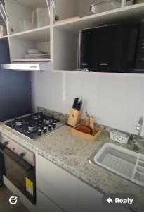 a kitchen counter with a stove and a microwave at Santa Martha-Apartment- Ocean view in Mirabel