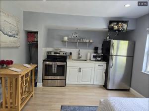 a kitchen with a stainless steel refrigerator and a table at Hideaway Steps off Atlantic Ave - Private Studio in Delray Beach +5 photos
