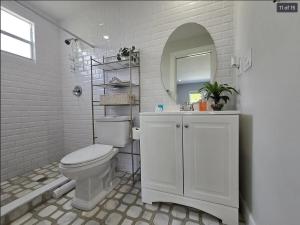 a bathroom with a toilet and a sink and a mirror at Hideaway Steps off Atlantic Ave - Private Studio in Delray Beach