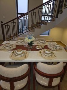 a table with chairs and plates and flowers on it at Jaymorgan Villas 4 bedroomed in Nanyuki