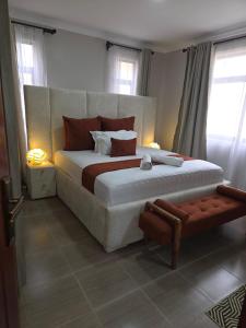 a bedroom with a large bed and two windows at Jaymorgan Villas 4 bedroomed in Nanyuki