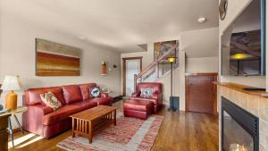 a living room with a red couch and a fireplace at The Buckeye in Red Lodge