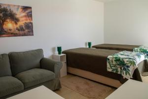 a living room with a bed and a couch at Casa da Quinta da Azeitona 2 - Piscina privada e BBQ na Serra da Gardunha in Fundão