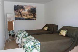 a bedroom with a bed and a painting on the wall at Casa da Quinta da Azeitona 2 - Piscina privada e BBQ na Serra da Gardunha in Fundão