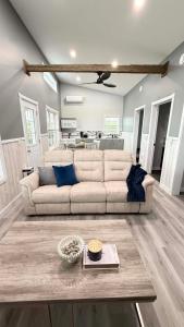 a living room with a white couch and a kitchen at Down East Cabins Ltd in Tracadie