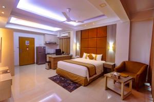 a hotel room with a large bed and a chair at Green Goose by Lakeshore Dhaka in Dhaka