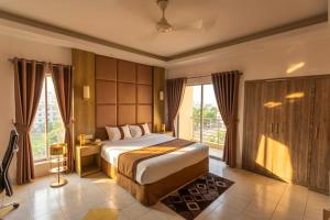 a bedroom with a bed and a large window at Green Goose by Lakeshore Dhaka in Dhaka