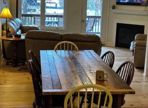 a wooden table and chairs in a living room with a couch at River & Vine in Helen