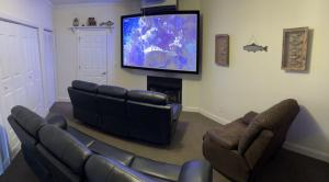 a living room with a couch and a flat screen tv at River & Vine in Helen +6 photos
