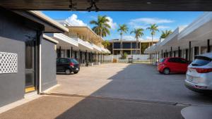 a parking lot with cars parked in front of buildings at Gladstone CBD Motel in Gladstone