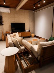 a living room with a couch and a projection screen at Casa Naru in Atins