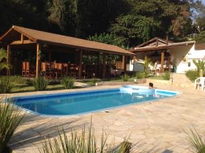 a swimming pool in a yard with a restaurant at POUSADA SuaCasita - 5 LAGOS in Mairiporã