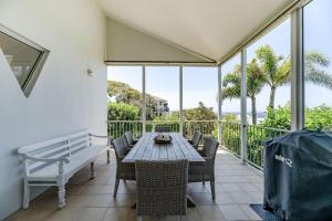 a dining room with a table and a bench at Luxe Beach House at Sunshine in Sunshine Beach