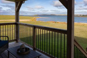 a balcony with a view of the water at Down East Cabins Ltd in Tracadie