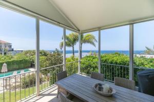 a porch with a table and a view of the ocean at Luxe Beach House at Sunshine in Sunshine Beach