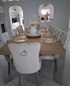 a dining room table with white chairs around it at Nyack's Palace And Boutique in Beaulieu