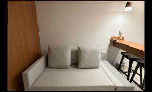 a white couch with two pillows sitting next to a table at Beach resort Salinas in Salinópolis