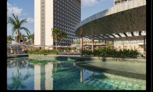 a large swimming pool in front of a tall building at Beach resort Salinas in Salinópolis