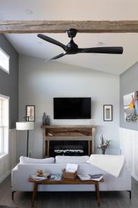 a living room with a white couch and a ceiling fan at Down East Cabins Ltd in Tracadie