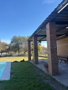 a pavilion with a picnic table and a pool at Los Romanos farm in Sauce Bajada