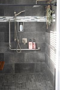 a bathroom with a shower with gray tiles at Down East Cabins Ltd in Tracadie +18 photos