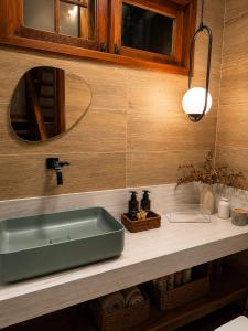 a bathroom with a green sink and a mirror at Casa Naru in Atins