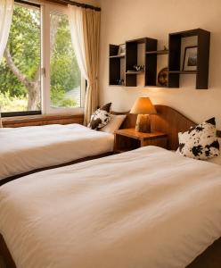 two beds in a room with a window at Country Inn Milky House in Niseko