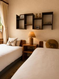 a bedroom with two beds and a lamp on a table at Country Inn Milky House in Niseko