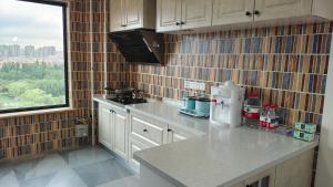 a kitchen with a counter top and a window at Yuan Apartment in Datong