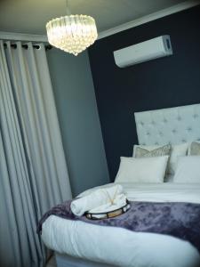 a bedroom with a bed with a chandelier at P Daisy in Rundu