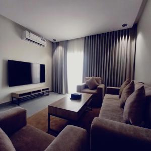 a living room with couches and a flat screen tv at منتجع هدب للشقق المخدومة in Taif